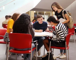 Saddleback College students studying around table.