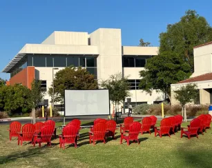 Red chairs lined up on the Saddleback Quad facing an outdoor movie screen