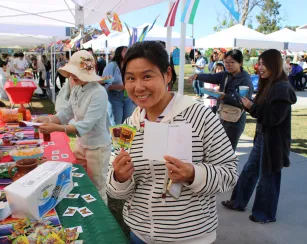 female holding candy surrounded by other adults at an event