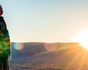 native american female outdoors with sun setting behind