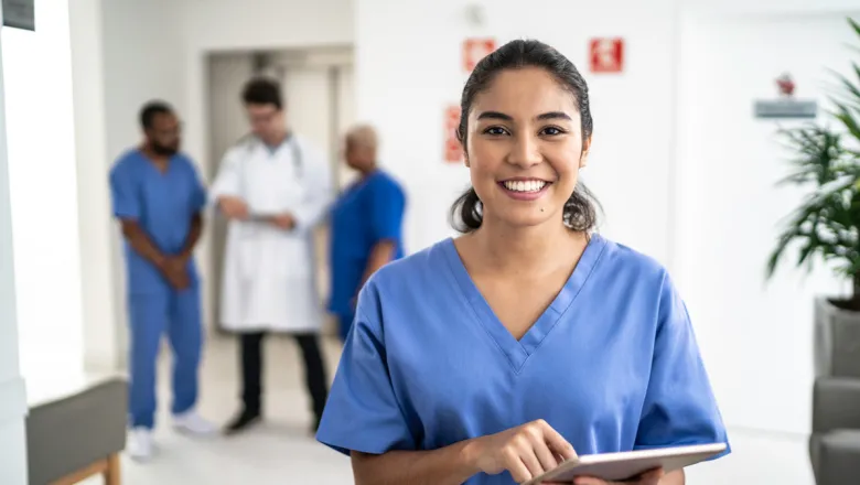 Medical professional in blue scrubs smiling at patient